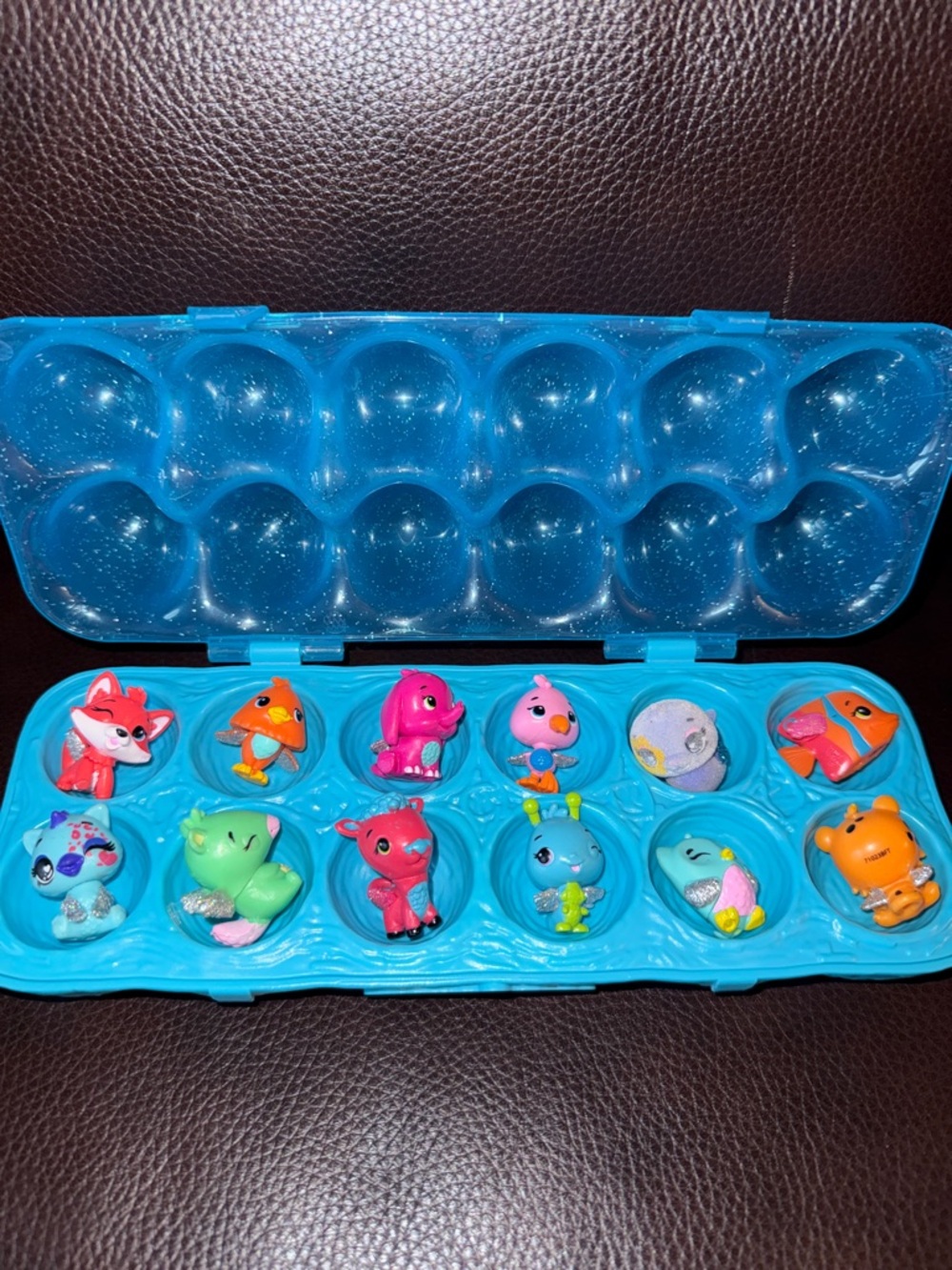 Hatchimals Blue Egg Carton Case with 12 Colorful Mini Animal Figures.